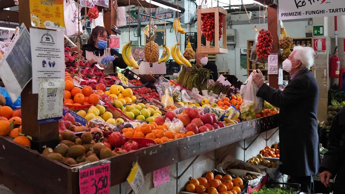 Un-hombre-compra-fruta-en-un-mercado-en-Roma